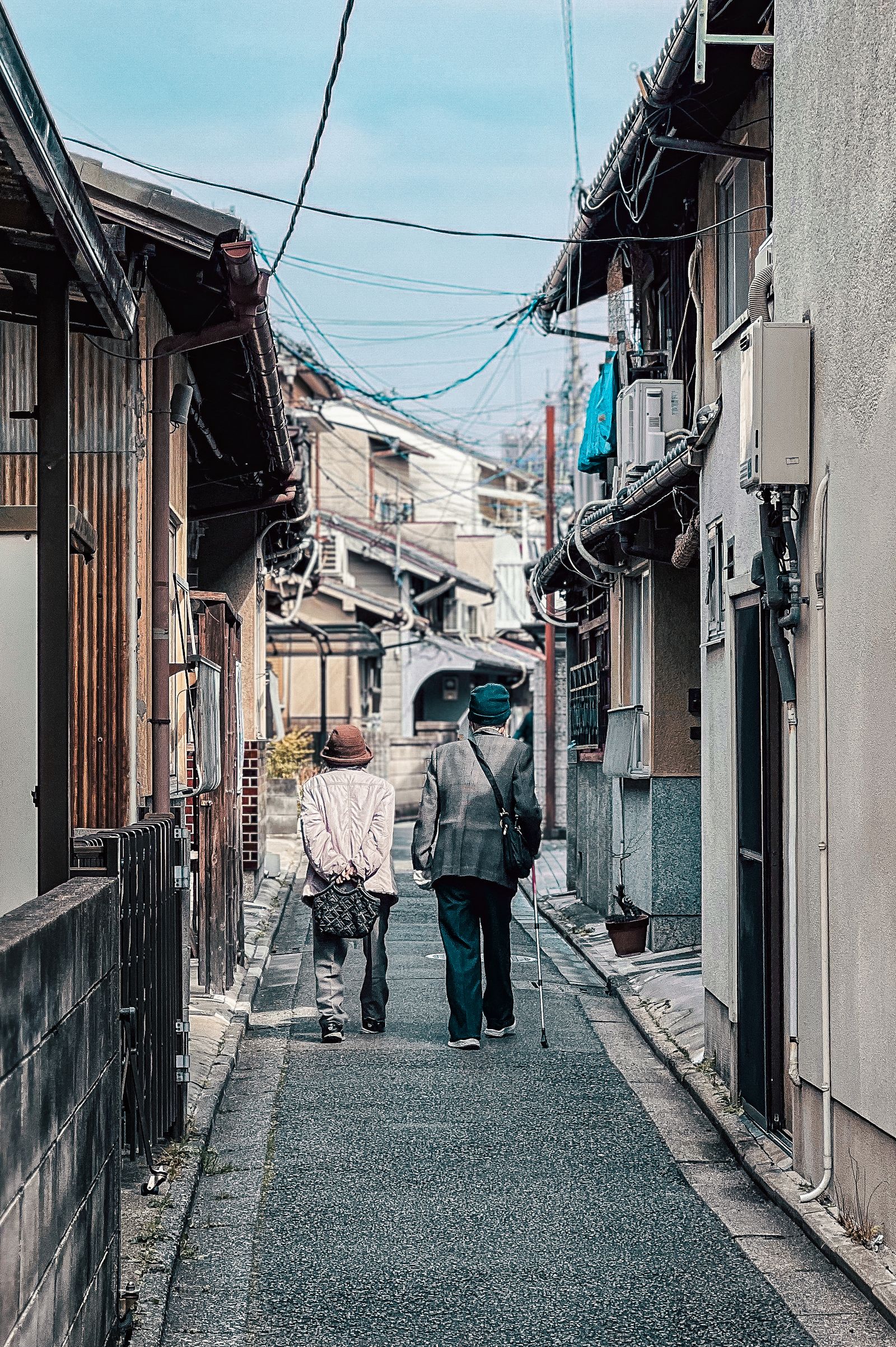 日本の路地を歩く高齢の夫婦の後ろ姿