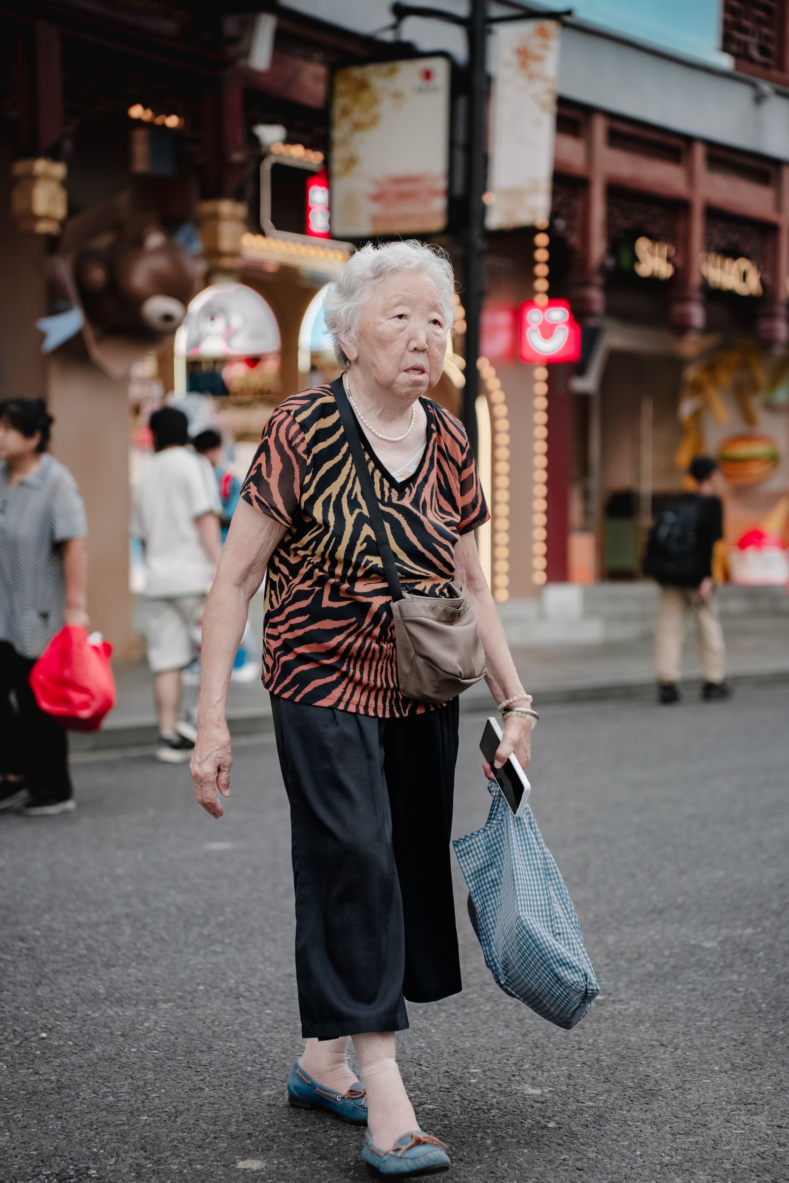 日本の商店街を歩く高齢女性のイメージ
